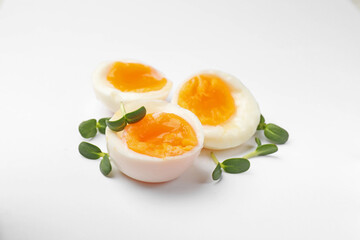 Soft boiled eggs with microgreens on white background