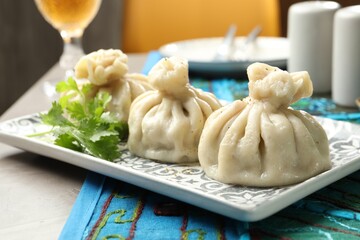 Delicious khinkali served with cilantro on grey table, closeup