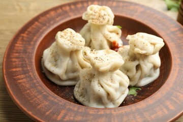 Tasty khinkali with spices on wooden table, closeup