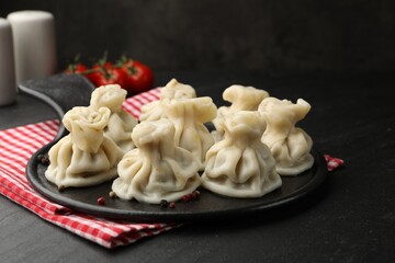 Delicious khinkali served on black table, closeup