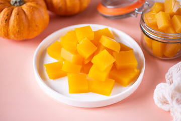 Pumpkin marmalade on a white plate. Cubes of marmalade on a plate. Home cooking. Close-up