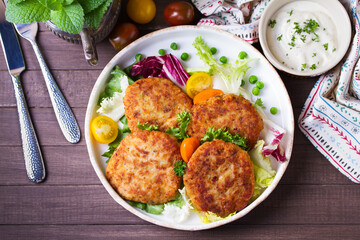 Fish cakes with vegetables and mashed potatoes. Fish patties or burgers. View from above, top studio shot