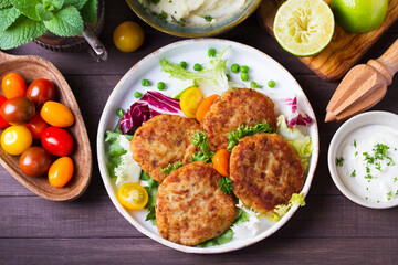 Fish cakes with vegetables and mashed potatoes. Fish patties or burgers. View from above, top studio shot