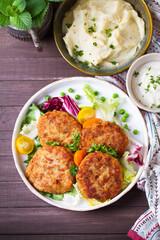 Fish cakes with vegetables and mashed potatoes. Fish patties or burgers. View from above, top studio shot