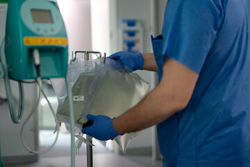 Doctor preparing intravenous infusion bag in hospital room