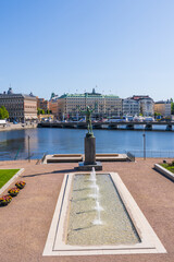 Helgeandsholmen island with a park with fountain, statue, overlooking Stockholm, Sweden, in summer