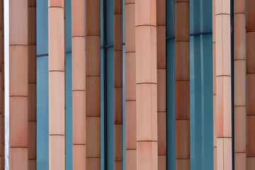 Architectural facade with vertical patterns in muted orange and blue shades representing contemporary design