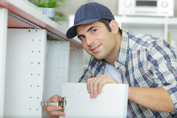 repairman is repairing the kitchen cupboard