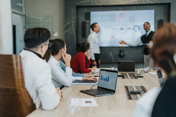 Naklejka premium Group of people engaged in a business meeting, discussing strategies and solutions. The team includes multicultural and multi-generational colleagues analyzing data and ideas collaboratively.