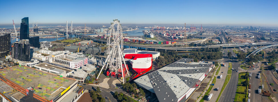 Fototapeta Aerial panorama of a large ferris wheel in front of city buildings and freeways