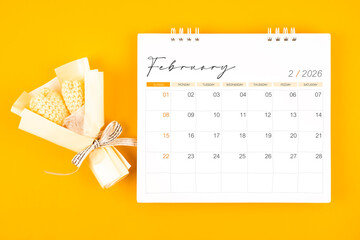 2026 February desk calendar and Yellow bouquet on yellow background.