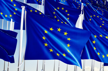 Many european union flags over blue sky background.