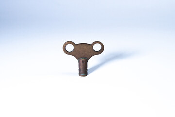Metal radiator key isolated on a white background, used for bleeding radiators in home heating systems.