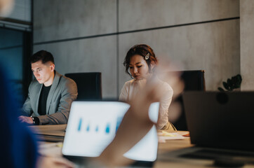 Multiracial team of people working together on business strategies in a modern office setting. They...
