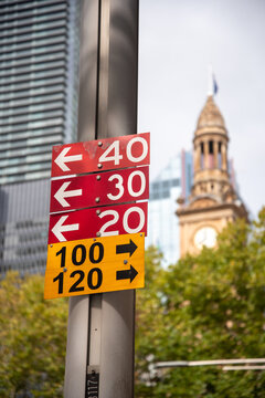 Bus routes sign with Town Hall clock tower out of focus in the background