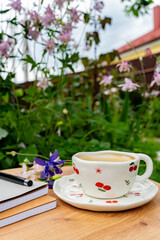 Cup of Coffee with Books and Flowers in the Garden