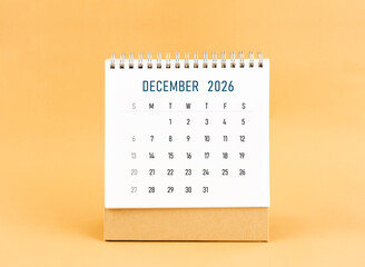 December 2026 desk calendar on yellow background, Front view.