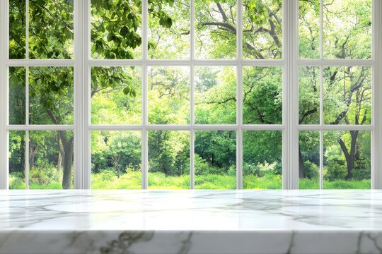 Fototapeta Marble countertop with a view of lush greenery through large windows