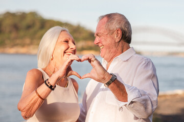 senior couple making heart hands together