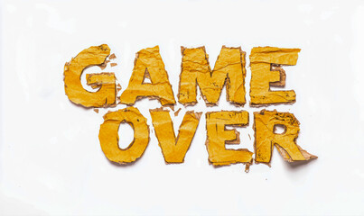 The phrase "GAME OVER" is spelled out using rough, torn yellow paper letters on a plain white background.