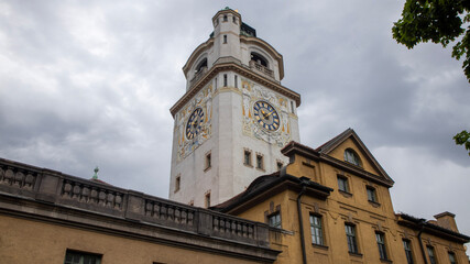 Historical Church Tower and Building in Munich Under a Cloudy Sky