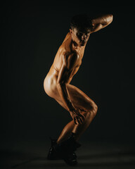 A creatively posed male figure, depicted under dramatic lighting in a studio, exuding strength.