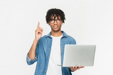 Happy excited african guy male student in casual clothes using holding laptop computer pc and...