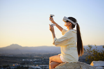 Woman enjoying virtual reality experience in nature at sunset