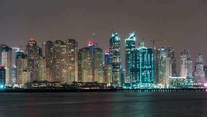 Fototapeta premium Dubai Marina skyline night timelapse as seen from island in Dubai, UAE.