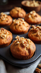 Banana nut muffins fresh baked with walnut topping in baking tray, warm and delicious homemade treat