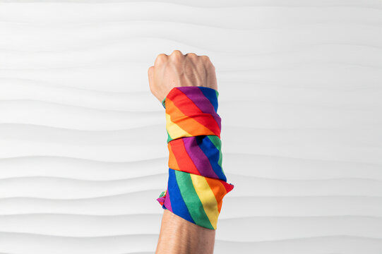 Brazo con pu&ntilde;o en alto con bandera pride en el brazo en se&ntilde;al de lucha y esfuerzo por derechos igualitarios