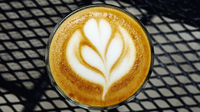 Tulip Latte Art in Glass Cup on Black Metal Table