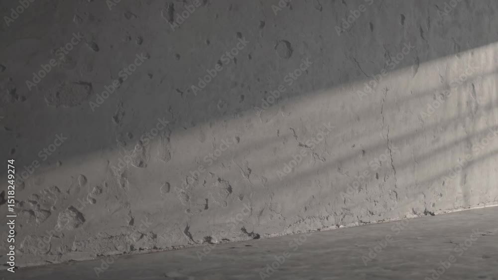 Aufkleber sunlight gliding over textured concrete surfaces, casting dynamic shadows within minimalist architec