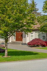Entrance of grey painted luxury house in spring with stair steps and nice landscape in Vancouver, Canada, North America. Day time on May 2025.
