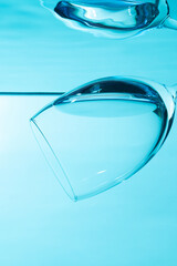 Glass in water isolated on blue background.	