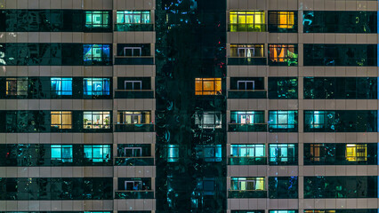 Fototapeta premium window of the multi-storey building of glass and steel lighting and people within timelapse