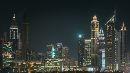 Dubai downtown skyline timelapse at night. Rooftop view of Sheikh Zayed road with numerous illuminated towers.
