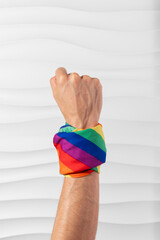 Brazo con puño en alto con bandera LGBT en el brazo en señal de lucha y esfuerzo por derechos igualitarios en formato vertical para redes sociales