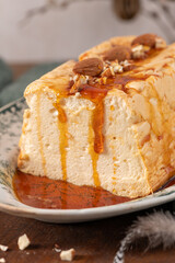 A close-up shot showcases a traditional caramelized egg white pudding known as molotof or molotov, generously drizzled with golden caramel and adorned with whole and chopped almonds