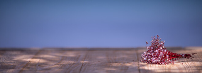 Summer vacation themed background - Bouquet of tiny Sedum flowers on a wooden table with sea in the...