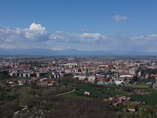 Fototapeta premium Drone shot of Novara's countryside showing the city edge, surrounding farmland, and a local highway cutting through the landscape.