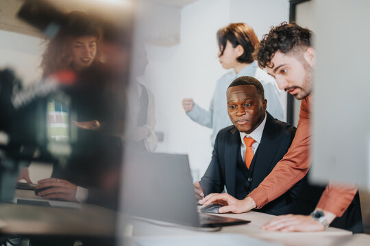 A group of professionals in a contemporary office work together on a project. They showcase teamwork, collaboration, and problem-solving in a productive business environment.