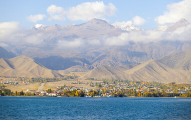 natural issyk-kul lakeside and town view in kyrgzstan with tian shan mountain range