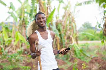 excited man using mobile phone in their farm land