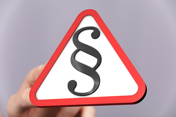 Stock photo of a hand holding a red triangle warning sign with a paragraph symbol.  Perfect for...