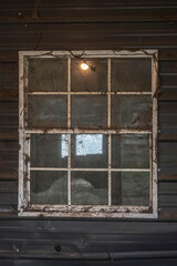 Close-up of an old window on an old wooden wall.