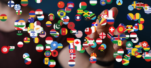 Person interacting with a digital display of world flags, symbolizing global connection and...