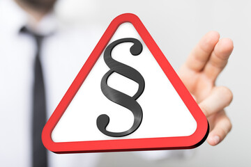 Stock photo of a hand holding a warning sign with a paragraph symbol.  Perfect for legal, law, or...