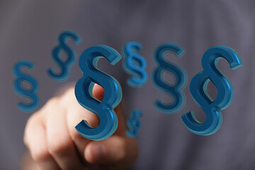 Abstract image of a hand interacting with 3D paragraph symbols, representing legal concepts, law,...