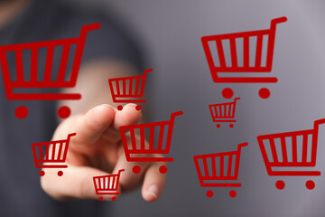 Person interacting with digital shopping carts, representing online shopping, e-commerce, and...